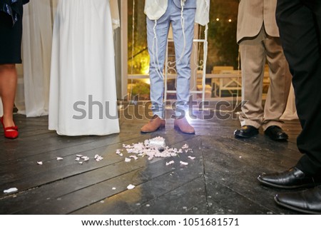 groom at jewish wedding steps on a glass Royalty-Free Stock Photo #1051681571