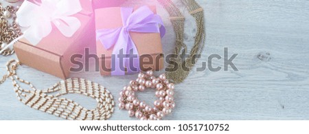 Banner gift boxes with gifts. Women's jewelry on a light wooden background. Toning