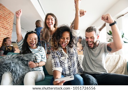 Group of diverse friends playing game on mobile phone Royalty-Free Stock Photo #1051726556