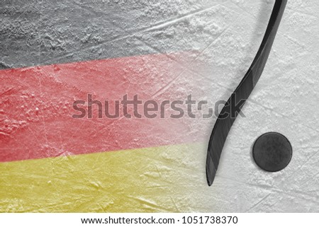 Hockey puck, stick and the image of the German flag on the ice. Concept, hockey