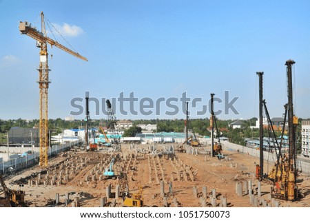 Large construction site with Cranes including several machine working on a building complex with clear blue sky background.Industry and Technology concept.