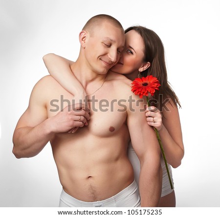 smiling pregnant woman holding a flower with her husband