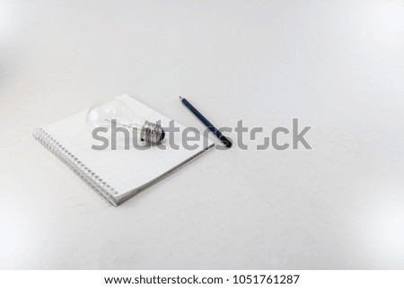 Light bulb and notebook with pencil On a white background , business planning concept, minimalist
