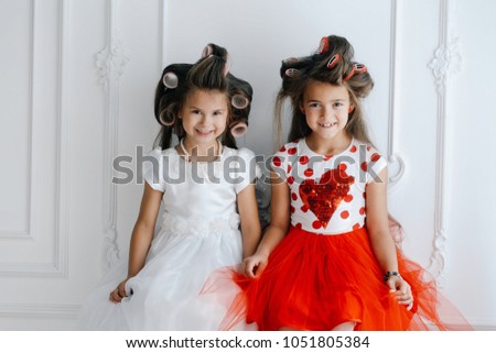 Close-up picture of two girls looking at camera slyly