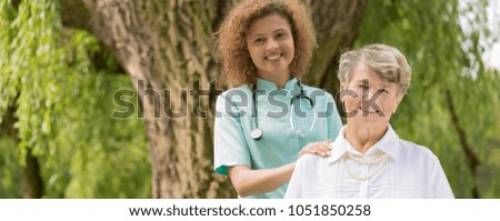 Optimistic portrait of a senior lady and her caregiver in the park