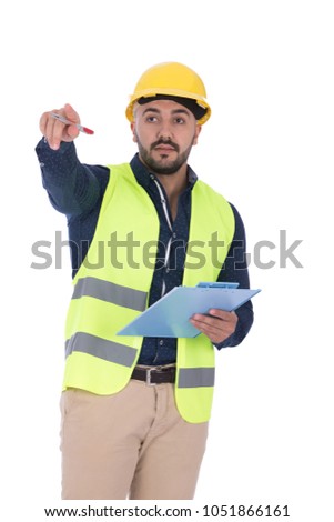 A young engineer standing, holding a clipboard and pointing, isolated on a white background.