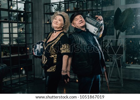 Happy couple of retirees in biker clothes.Concepts about seniority.Unusual retired couple.Biker grandmother and biker grandfather. Biker couple.Happy pensioners