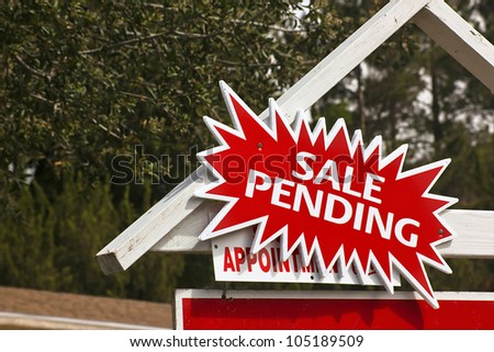 Real estate sign has a sale pending notice.