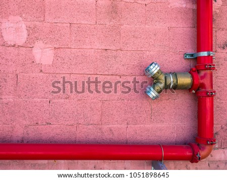 Fire hydrant red color on the wall of an industrial building.
Copy space