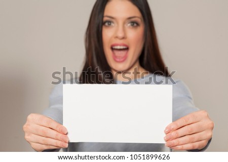 Happy woman showing empty blank paper card sign with copy space for text