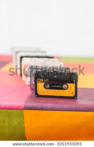 Cassette tapes on a colorful checked tablecloth