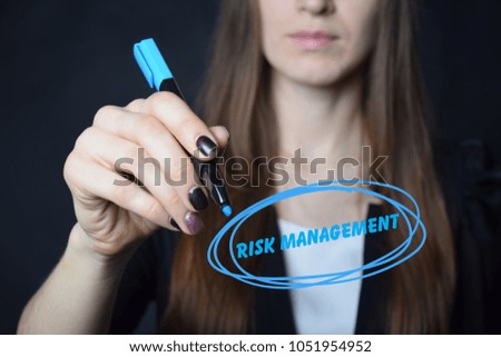 The businessman writes a blue marker inscription:RISK MANAGEMENT
