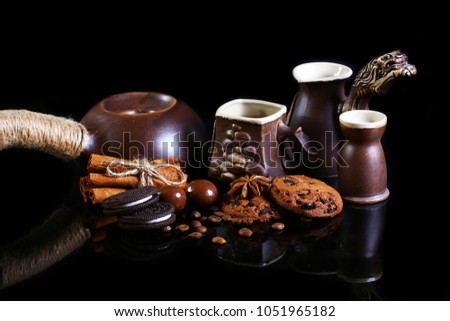 close-up set of coffee dishes, espresso coffee, milk, round crunchy chocolate cookies with coffee beans, sticks of cinnamon on a black background, macro, set.