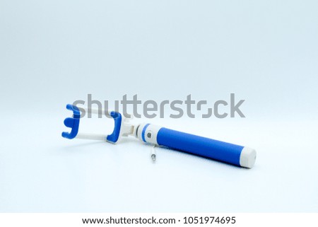 An extensible selfie stick with an adjustable clamp on white background.