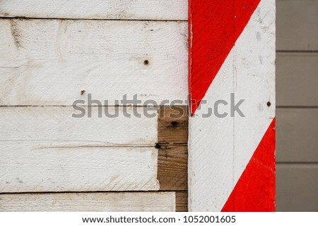 Red and white wooden barriers placed along construction site wall .