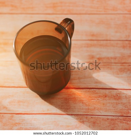 Glass of tea on a wooden table. Photo of food. The light of the western sun from the window. Atmospheric