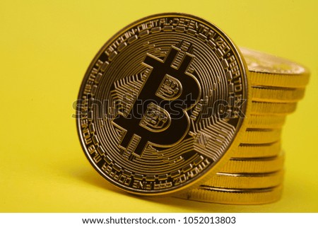 Stack of golden bitcoin on yellow brown concept shot