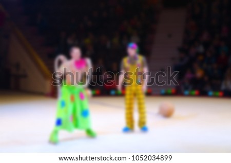 Abstract blurred image of tour of circus on ice. Performance of clown group in defocus, background
