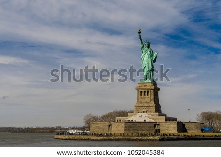Front view of The Statue of Liberty on Liberty island with cloud blue sky background, Landmarks of New York City, USA