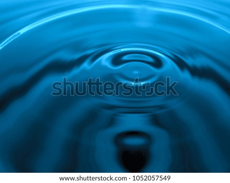 Macro photography of blue water drop / ink drops splash and ripples, wet, conceptual for environmental, conservation, drought, artistic, for website banners, backgrounds, and graphics with copy space.