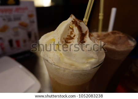 Ice cream - milkshake cocholate - delicious beverage. White cream with some granule compose the delicious ice cream in the glass. Composition of ice cream, glass and the straw combine good picture.