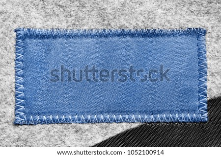 Blank blue clothes label on textile background closeup