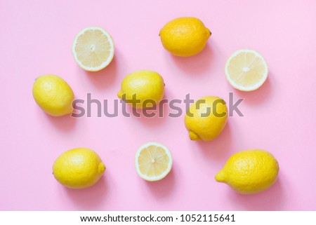 Fresh whole and sliced lemon on punchy pink background. Flat lay. Royalty-Free Stock Photo #1052115641