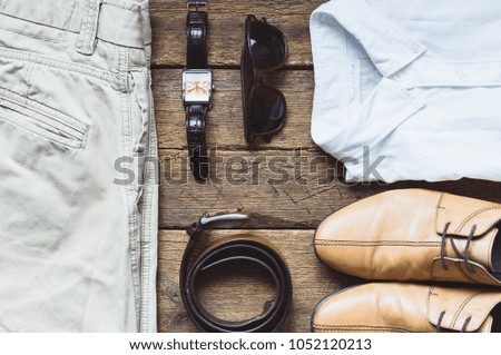 Men's clothes and accessories on wooden background. Top view