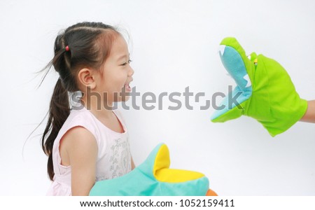 Little Asian child girl hands playing animal puppets on white background. Educations concept.