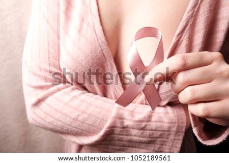 woman holding pink ribbon, breast cancer awareness. October Breast Cancer Awareness month, Woman in pink with hand holding Pink Ribbon for suppor. Cancer, health, support concept