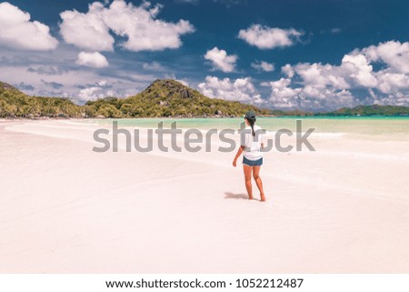 white beach Praslin Island during vacation Seychelles ,Young woman at the beach by a coconut palm tree