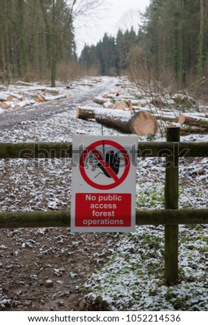 "No Public Access Forest Operations" Sign in a Landscape of Douglas Fir Logs Covered with Snow in Eggesford Forest in RUral Devon, England, UK