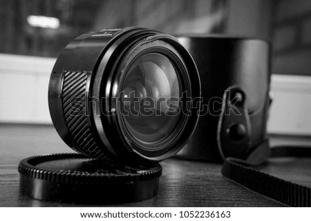 Close-up shot of photo lens on a table.camera accessories, photographer concept design black and white