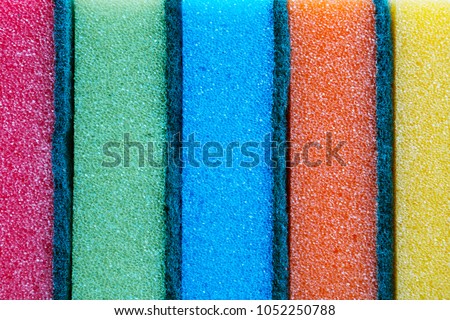 Colorful sponges on kitchen texture background