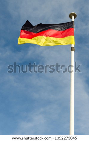 A germany flag is floating in a blue sky