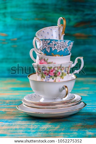 Stack of vintage tea cups on turquoise background Royalty-Free Stock Photo #1052275352