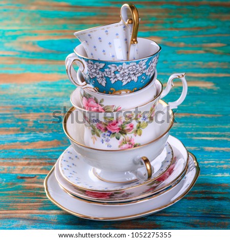 Stack of vintage tea cups on turquoise background Royalty-Free Stock Photo #1052275355