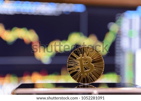 golden bitcoin and chart on monitor