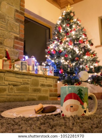 Cookies and milk for Santa in front of Christmas tree and Christmas cards