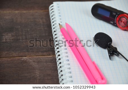 voice recorder and microphone, notepad on a wooden table. Journalist, online training, remote work