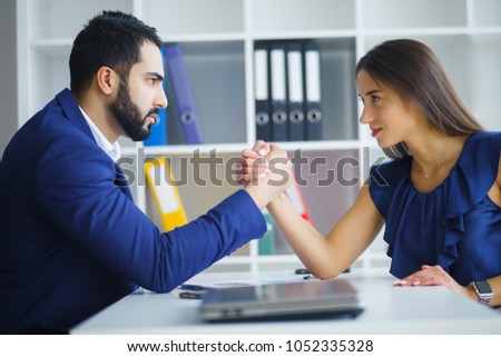 Man and woman arm wrestling on table