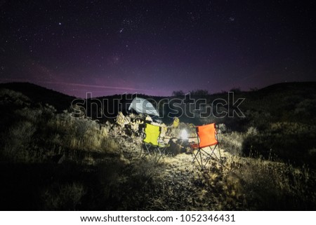 Night camping with tent in desert with scenic night sky with stars
