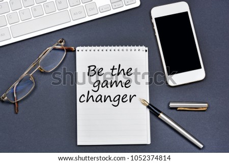 Be the game changer. Text on notebook on a black background