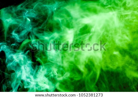 Green cloud of smoke of  black isolated background. Background from the smoke of vape