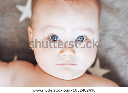 Funny and cute face baby looking at camera. An adorable little boy close up.