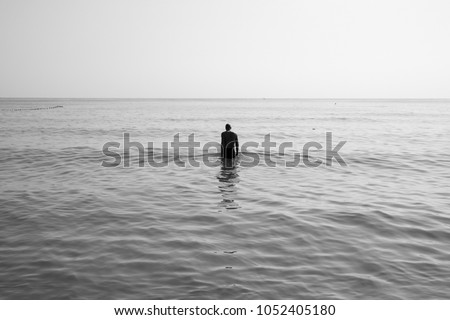 black and white picture
Man walks into the sea with sadness.