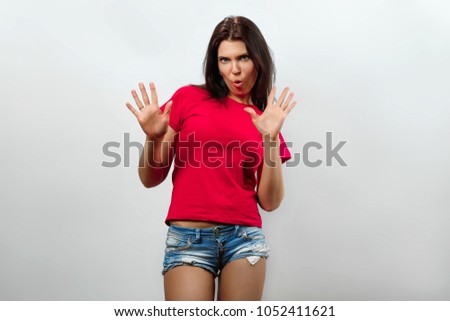 A young, beautiful girl shows a gesture makes a frightened gesture with her hands, protects herself from someone, asks to immediately stop it. His guy says that stay away from me, shows a stop sign.