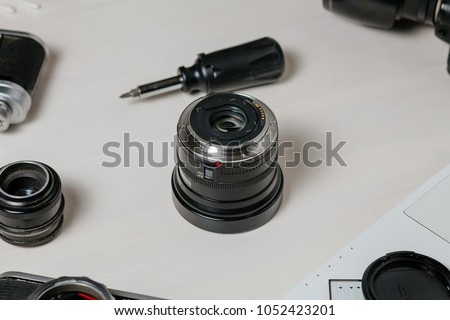 Repair of photographic equipment. Engineer - technician engineer disassembling, align and adjusts photo camera lens, optic part.