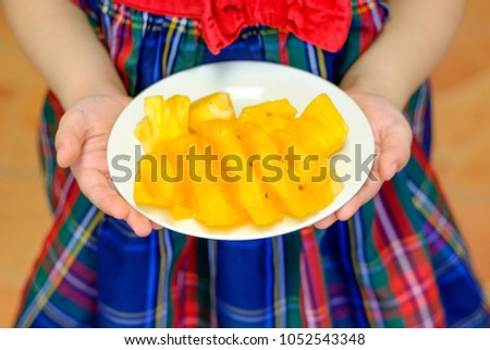 yellow pineapple on dish in children and kids hand blurry picture