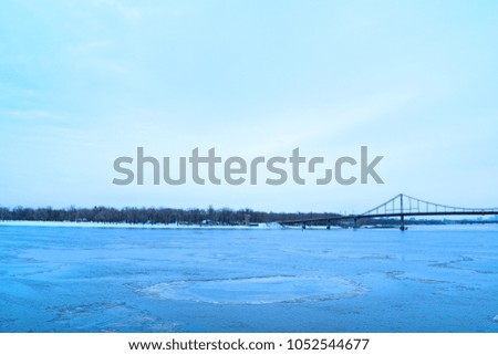 View of the river and the bridge in the winter in the city
